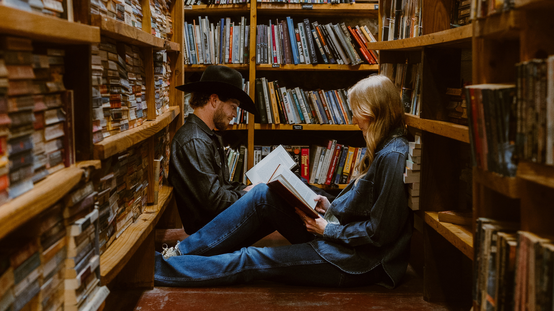 a man and woman reading surrounded by books 
